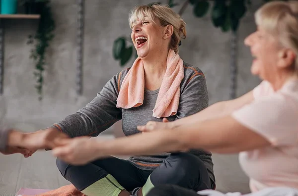 woman circled up laughing yoga class